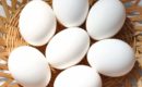 Mehrere weiße Hühnereier in einem geflochtenen Korb